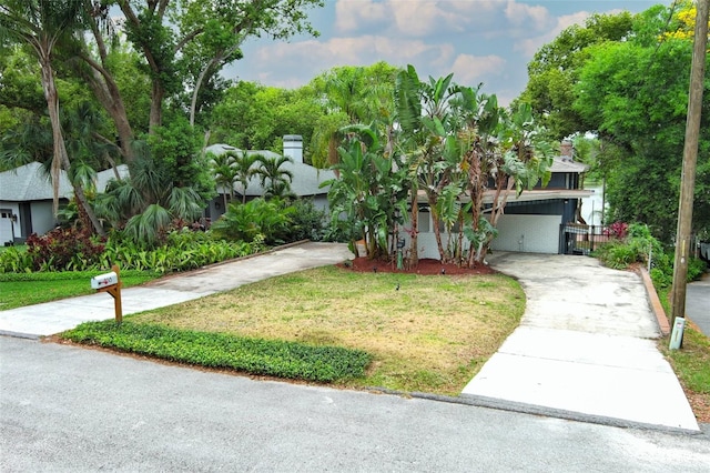 view of front of house featuring a front yard, an attached carport, and concrete driveway
