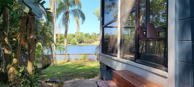 exterior space featuring fence and a water view