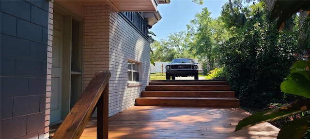 exterior space with brick siding and a deck