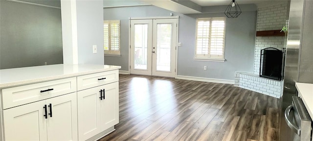 interior space featuring dark wood-style flooring, french doors, baseboards, and a fireplace
