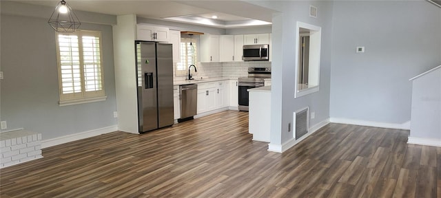 kitchen featuring tasteful backsplash, baseboards, dark wood-style flooring, light countertops, and stainless steel appliances