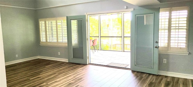 doorway with baseboards and wood finished floors