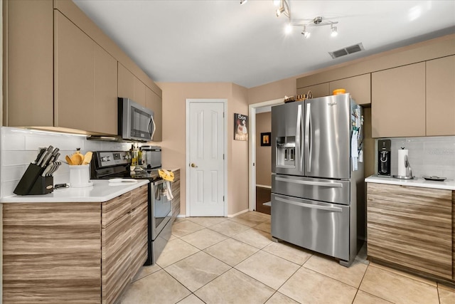 618 Via Milano, Apopka, FL 32712 - kitchen featuring light tile patterned floors, visible vents, light countertops, appliances with stainless steel finishes, and decorative backsplash