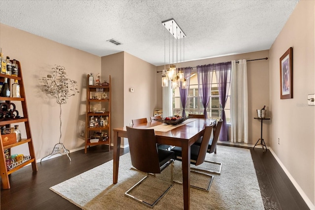 618 Via Milano, Apopka, FL 32712 - dining area featuring a chandelier, a textured ceiling, visible vents, and wood finished floors