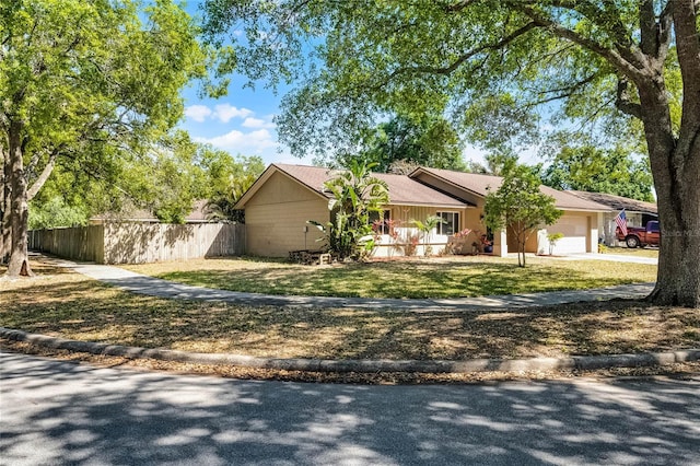 607 Wavecrest Dr, Orlando, FL 32807 - ranch-style house with driveway, an attached garage, fence, and a front yard