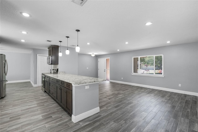 607 Wavecrest Dr, Orlando, FL 32807 - kitchen with light stone countertops, appliances with stainless steel finishes, recessed lighting, and wood finished floors