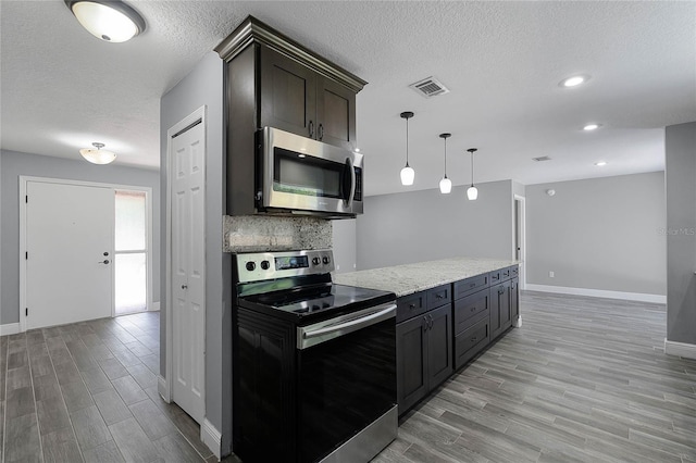 607 Wavecrest Dr, Orlando, FL 32807 - kitchen with wood tiled floor, visible vents, tasteful backsplash, and appliances with stainless steel finishes