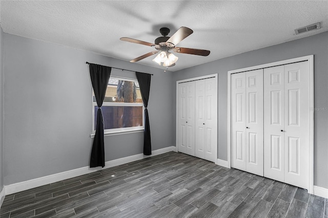 607 Wavecrest Dr, Orlando, FL 32807 - unfurnished bedroom with multiple closets, baseboards, visible vents, ceiling fan, and dark wood-style flooring