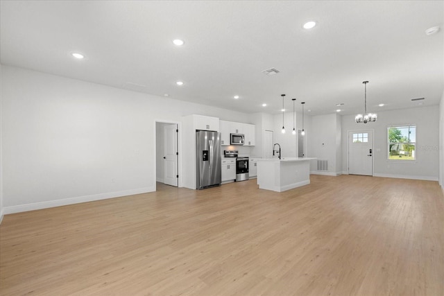 unfurnished living room featuring an inviting chandelier, a sink, light wood-style floors, and recessed lighting