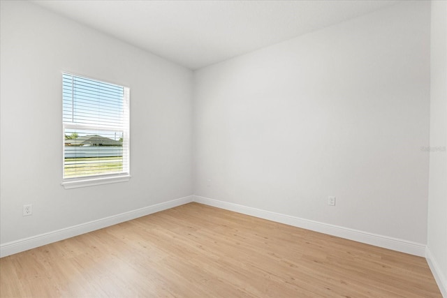 empty room with baseboards and light wood finished floors