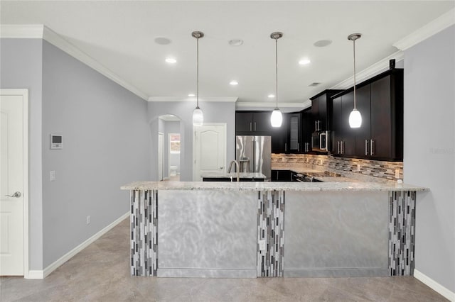 kitchen featuring tasteful backsplash, recessed lighting, light stone countertops, appliances with stainless steel finishes, and arched walkways