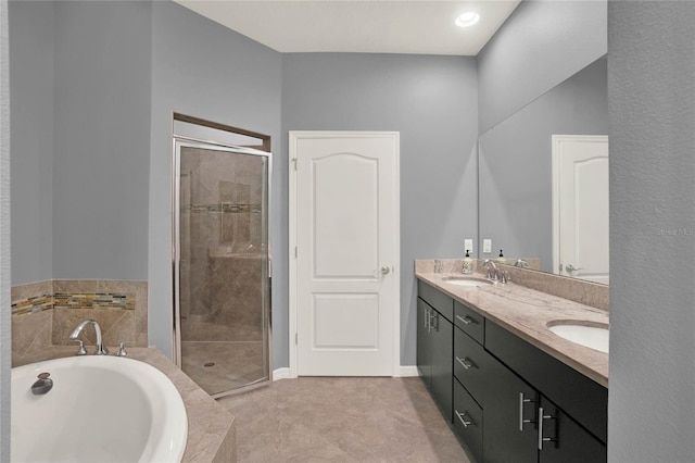 full bathroom featuring double vanity, a sink, a garden tub, and a stall shower
