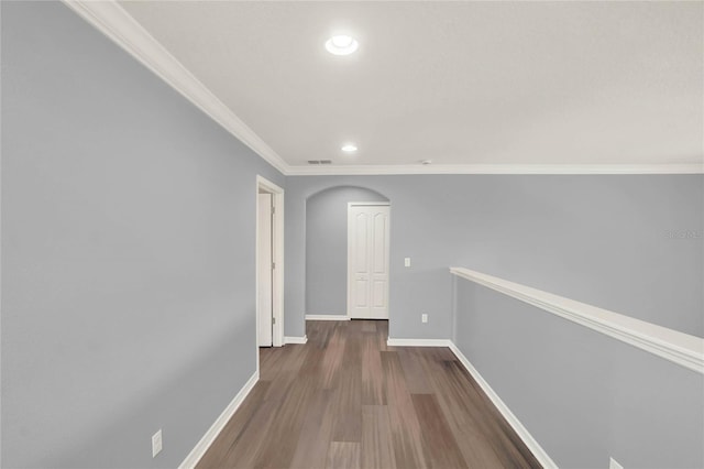 corridor featuring arched walkways, wood finished floors, baseboards, and recessed lighting