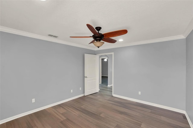 empty room with wood finished floors, baseboards, a ceiling fan, and visible vents