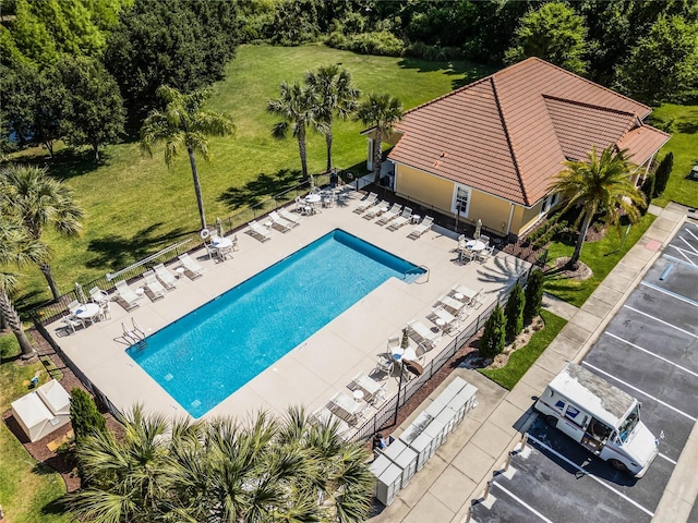 community pool with a patio area and fence