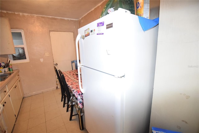 2220 Ave F NW, Winter Haven, FL 33880 - kitchen with baseboards, light tile patterned floors, light countertops, freestanding refrigerator, and a sink