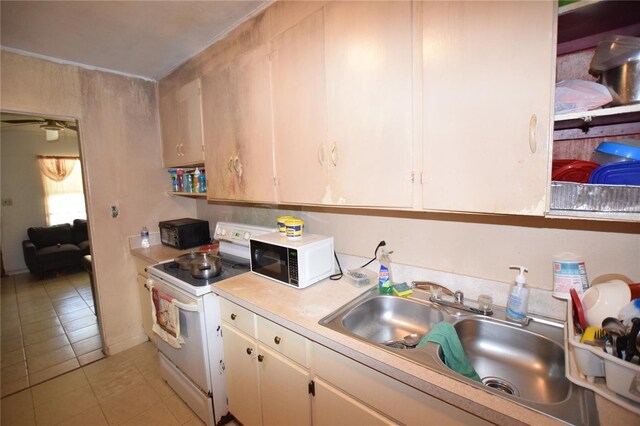 2220 Ave F NW, Winter Haven, FL 33880 - kitchen featuring white appliances, light tile patterned floors, white cabinetry, light countertops, and a sink