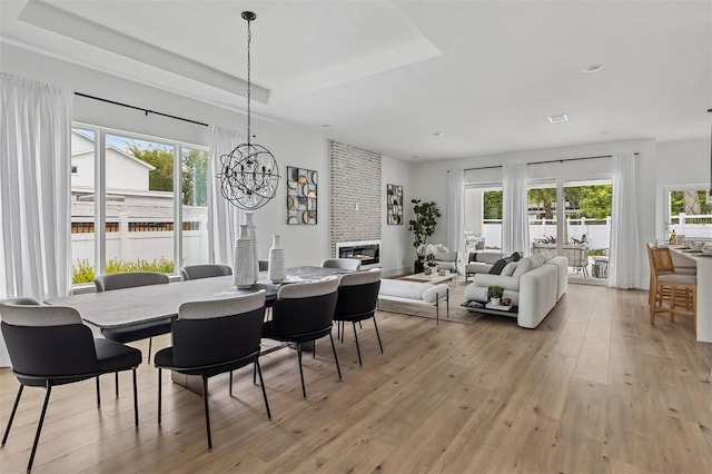 2408 Lafayette Ave, Winter Park, FL 32789 - dining space featuring a wealth of natural light, light wood-type flooring, a chandelier, and a raised ceiling