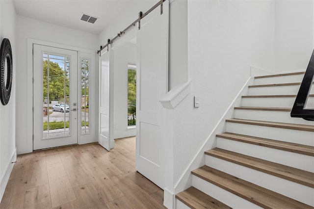 2408 Lafayette Ave, Winter Park, FL 32789 - entryway with stairway, a barn door, visible vents, and light wood-style floors