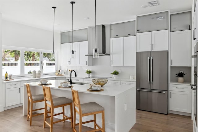 2408 Lafayette Ave, Winter Park, FL 32789 - kitchen with visible vents, a center island with sink, high quality fridge, a sink, and wall chimney range hood
