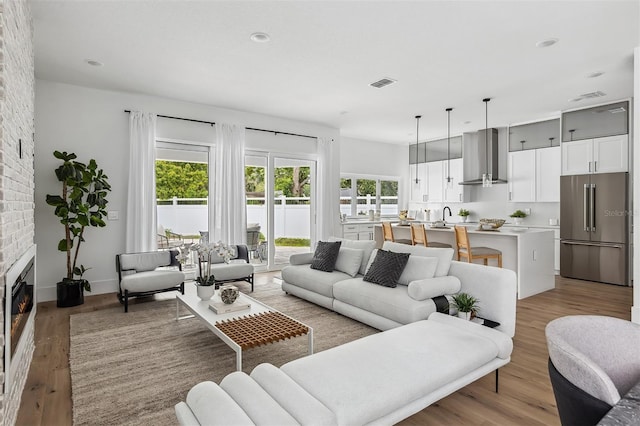 2408 Lafayette Ave, Winter Park, FL 32789 - living area with light wood-type flooring, a brick fireplace, recessed lighting, and visible vents