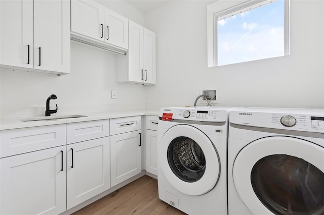 2408 Lafayette Ave, Winter Park, FL 32789 - laundry room featuring washing machine and clothes dryer, a sink, cabinet space, and light wood-style floors