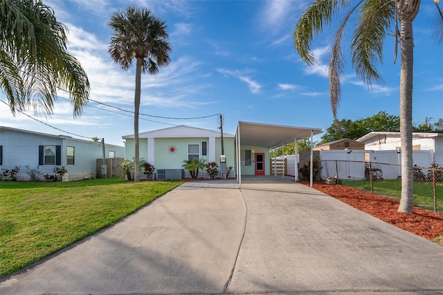 view of front of home featuring a front lawn, driveway, a carport, and fence