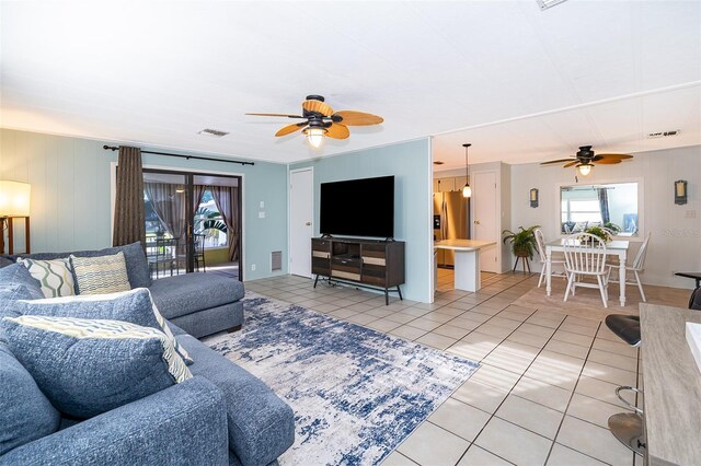 living area featuring visible vents, ceiling fan, and light tile patterned floors