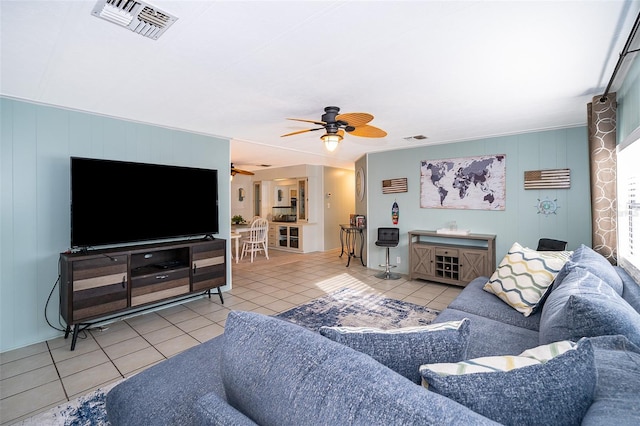 living room with ceiling fan, visible vents, and light tile patterned floors