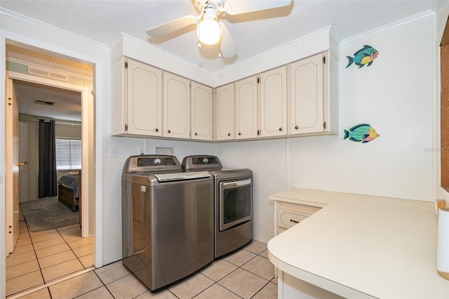 washroom with cabinet space, independent washer and dryer, crown molding, and light tile patterned floors