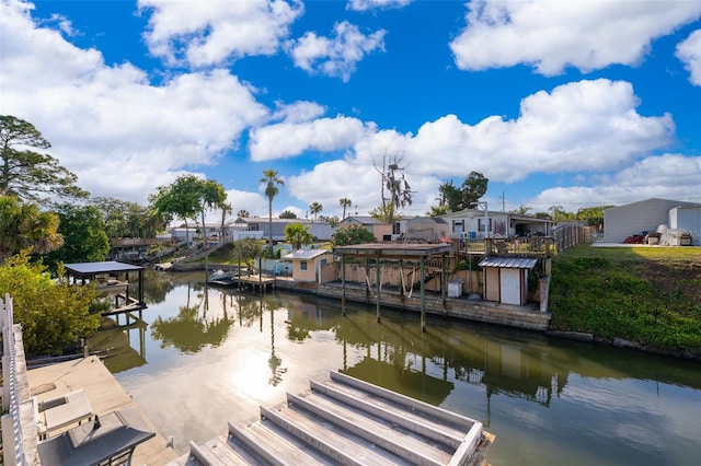 dock area featuring boat lift, a water view, and a residential view