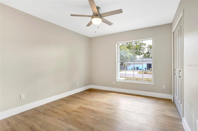 unfurnished room featuring baseboards, a ceiling fan, and light wood finished floors