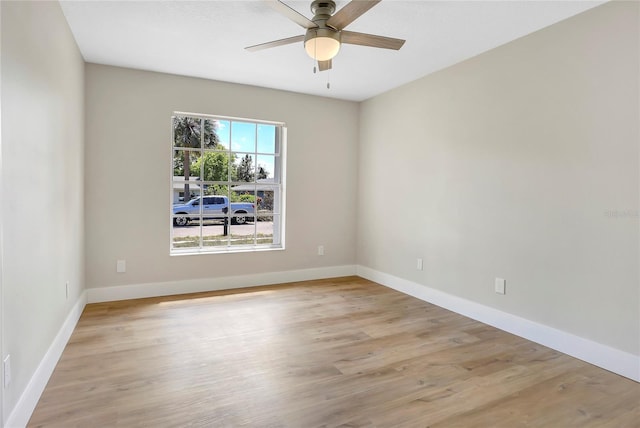 empty room featuring baseboards, light wood-type flooring, and a ceiling fan