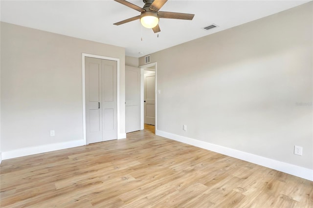 unfurnished bedroom featuring baseboards, visible vents, a closet, and light wood-type flooring