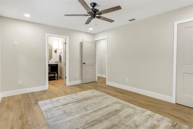unfurnished bedroom featuring connected bathroom, light wood finished floors, baseboards, visible vents, and recessed lighting