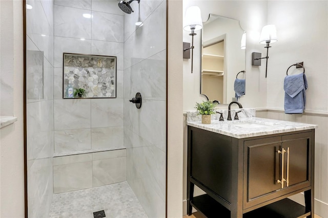 full bath featuring a tile shower and vanity