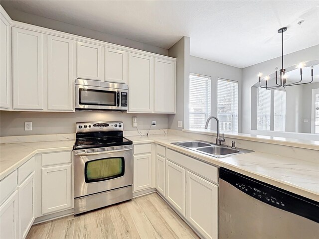 10852 Spider Lily Dr Unit S, Orlando, FL 32832 - kitchen with appliances with stainless steel finishes, a sink, light wood-type flooring, white cabinets, and light countertops