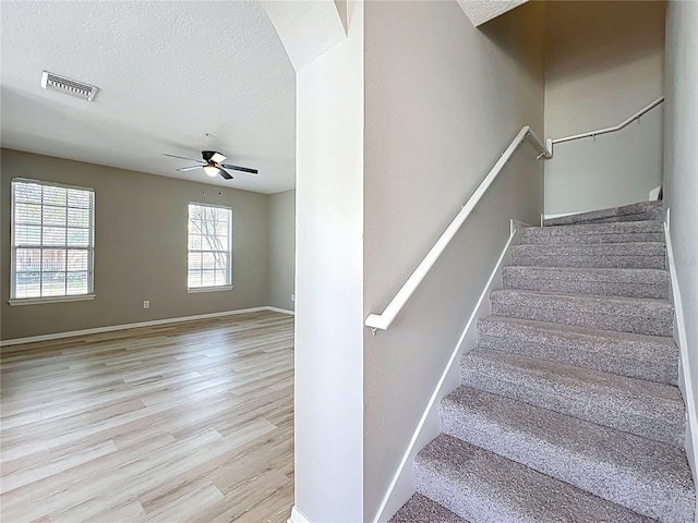 10852 Spider Lily Dr Unit S, Orlando, FL 32832 - stairs featuring a ceiling fan, wood finished floors, a textured ceiling, arched walkways, and baseboards
