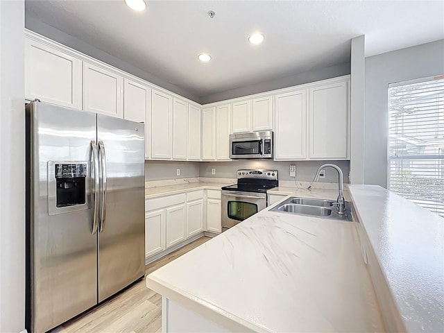 10852 Spider Lily Dr Unit S, Orlando, FL 32832 - kitchen with appliances with stainless steel finishes, a sink, recessed lighting, white cabinets, and light wood-style floors