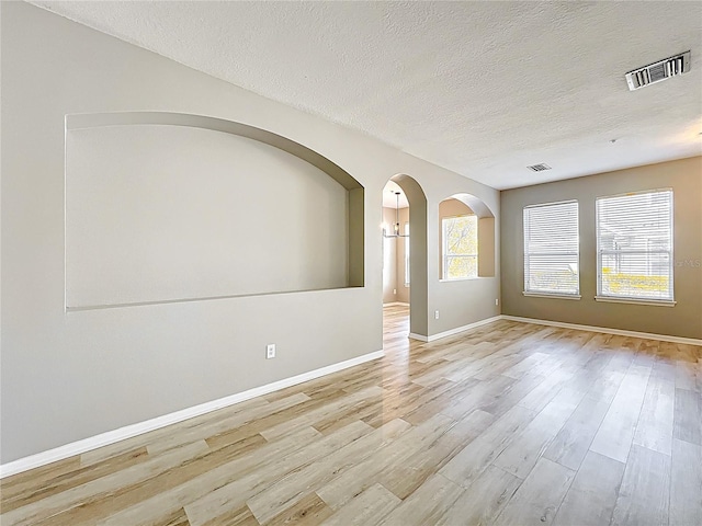 10852 Spider Lily Dr Unit S, Orlando, FL 32832 - empty room featuring wood finished floors, a textured ceiling, baseboards, and arched walkways