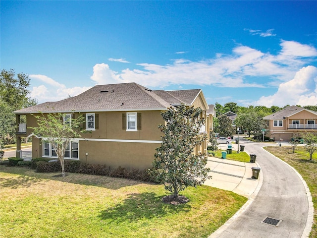 10852 Spider Lily Dr Unit S, Orlando, FL 32832 - view of side of home with stucco siding, a lawn, and roof with shingles