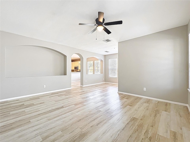 10852 Spider Lily Dr Unit S, Orlando, FL 32832 - unfurnished room featuring a ceiling fan, light wood-style flooring, baseboards, and arched walkways