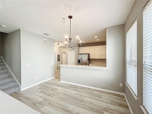 10852 Spider Lily Dr Unit S, Orlando, FL 32832 - kitchen with stainless steel fridge with ice dispenser, light wood-type flooring, a chandelier, a peninsula, and baseboards
