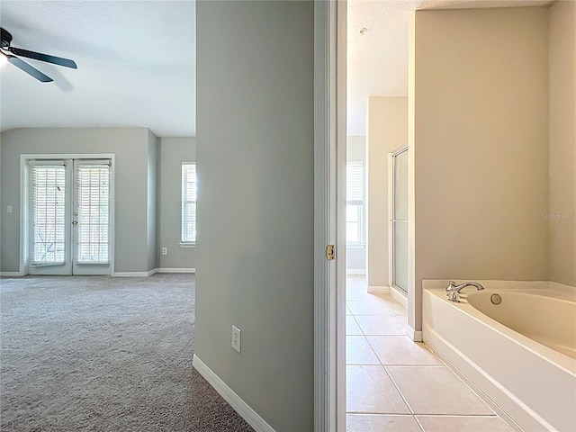 10852 Spider Lily Dr Unit S, Orlando, FL 32832 - bathroom featuring a ceiling fan, a garden tub, a shower stall, tile patterned floors, and baseboards