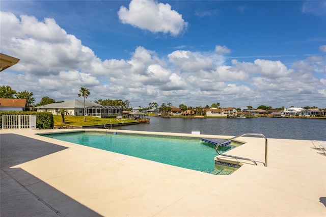 pool with a patio, a residential view, and a water view