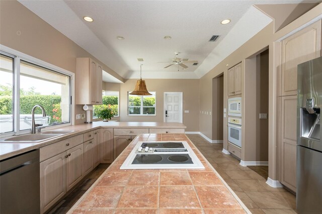 kitchen featuring a sink, ceiling fan, visible vents, a peninsula, and appliances with stainless steel finishes