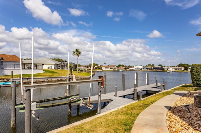 dock area featuring a residential view, a lawn, a water view, and boat lift
