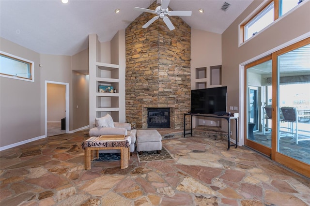 living area featuring stone flooring, high vaulted ceiling, plenty of natural light, and visible vents