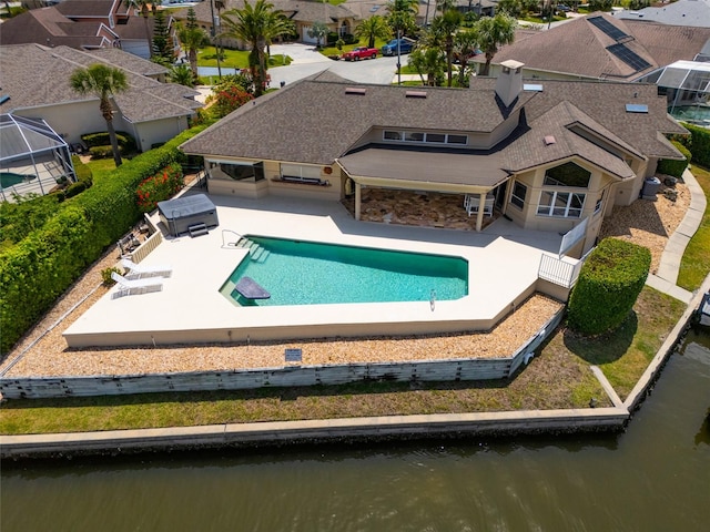 outdoor pool featuring a residential view, a water view, and a patio area