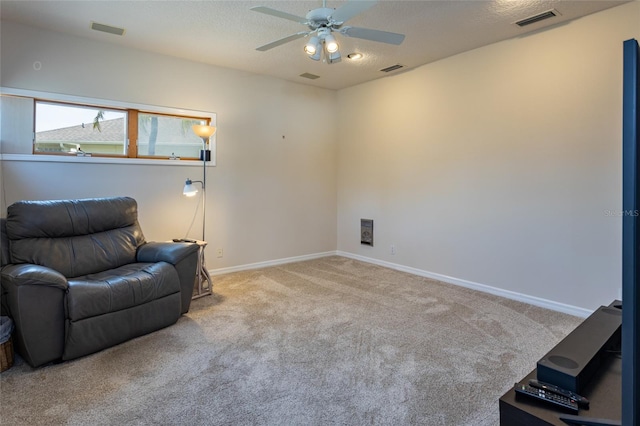 living area with carpet, visible vents, ceiling fan, and baseboards